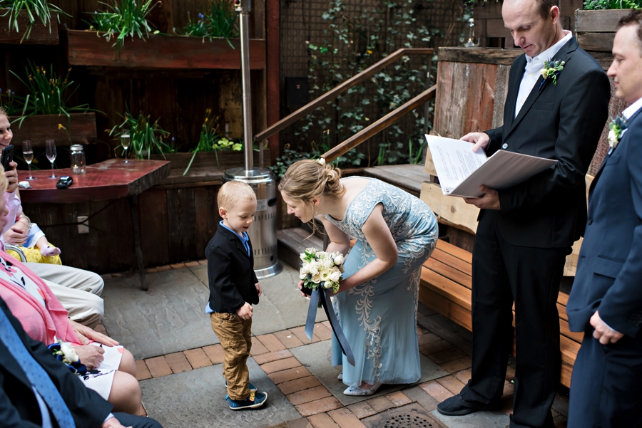 The young ring bearer delivers the rings to the bride during the wedding ceremony.